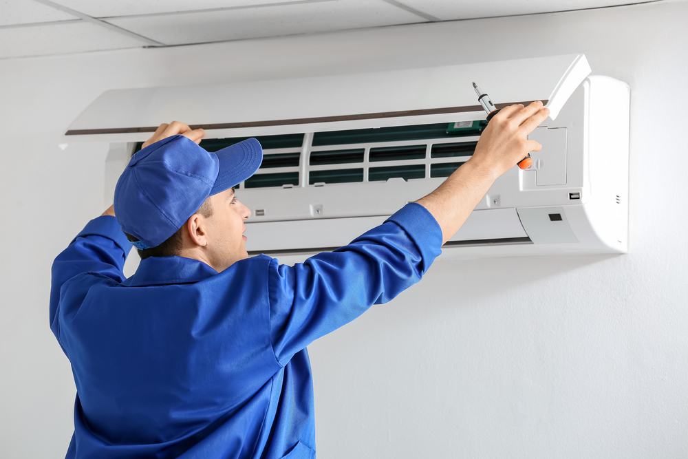 young,electrician,repairing,air,conditioner,indoors
